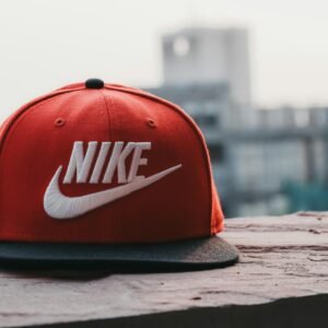 Red cap with logo on a rooftop against an urban cityscape backdrop in daylight.